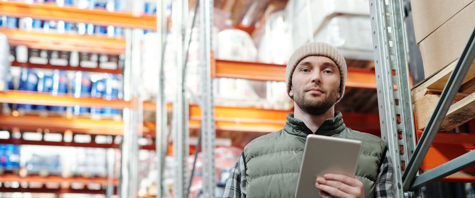 Field sales rep using a tablet among stocked shelves
